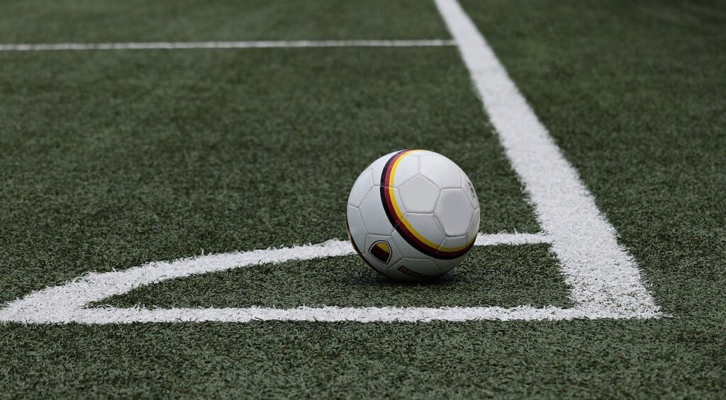 Córner del campo de futbol con la pelota en el centro